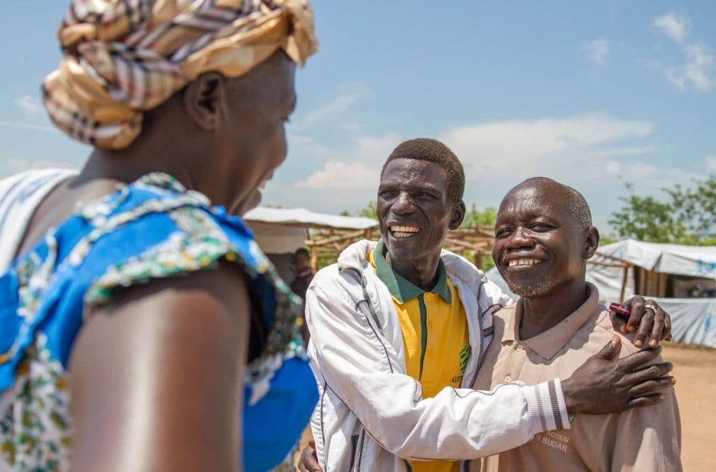 Photo montrant un réfugié qui rencontre un vieil ami sur le marché du camp des réfugiés en Ouganda.