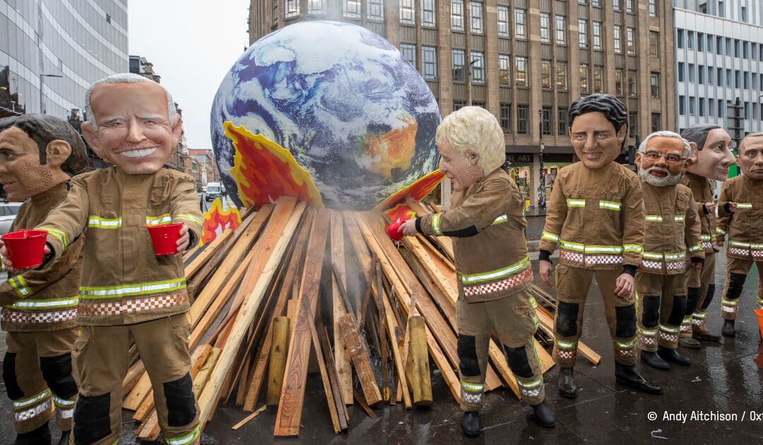 caricature de leaders mondiaux tentant d'éteindre avec peu d'eau une planète en feu