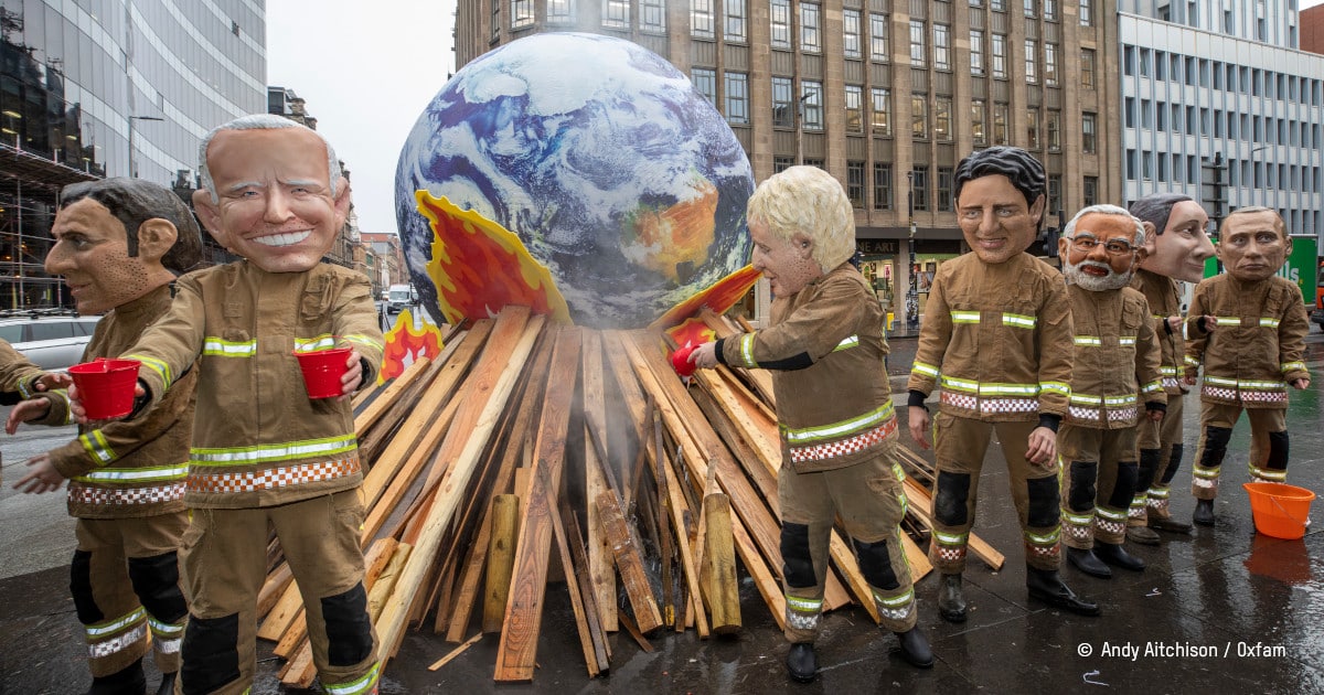 caricature de leaders mondiaux tentant d'éteindre avec peu d'eau une planète en feu
